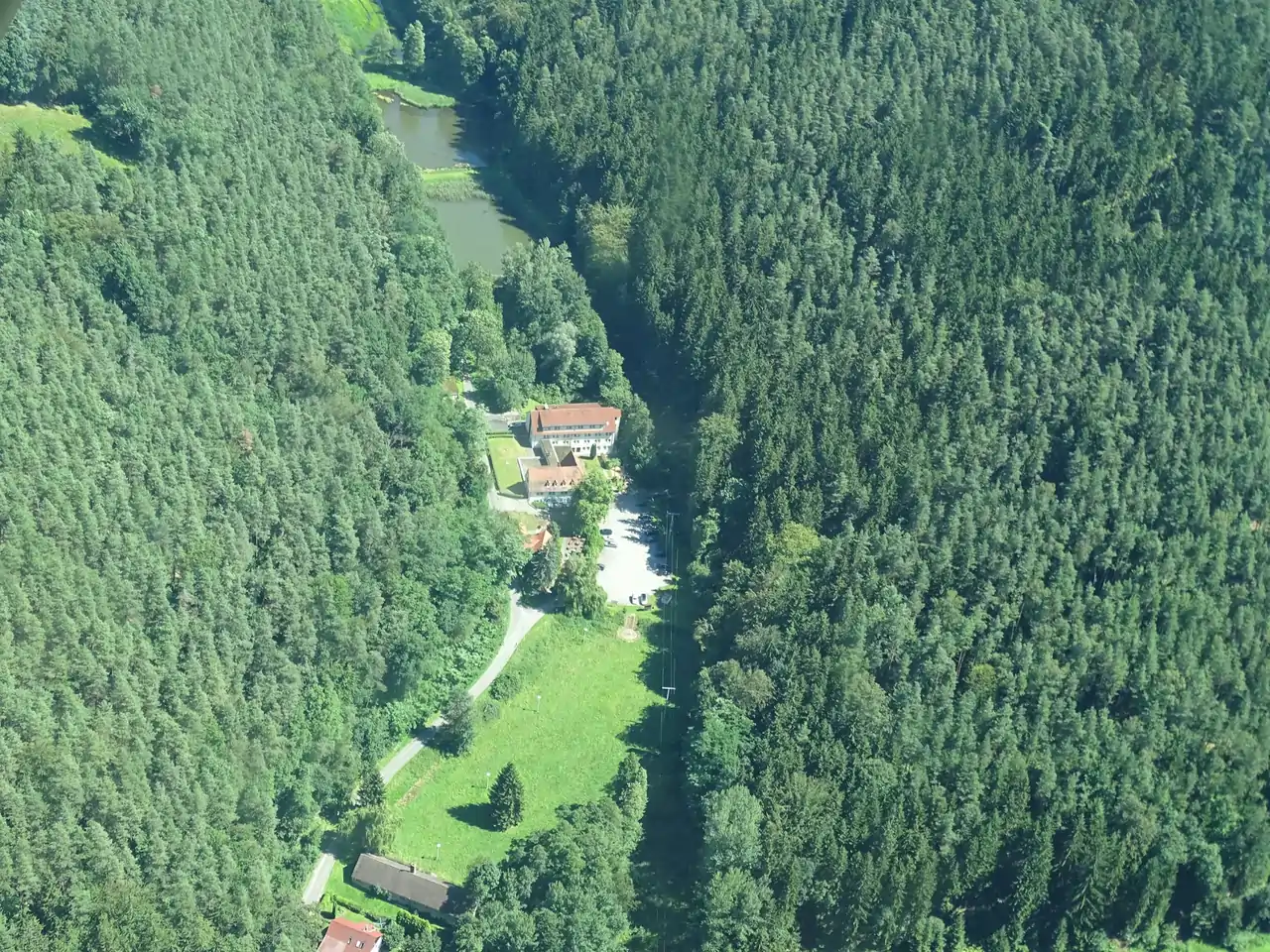 Eine Drohnenaufnahme des Waldhotel Linzmühle mit Umgebung.